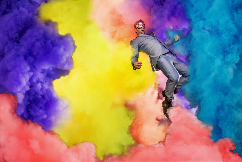 Chase Jarvis jumps into a colorful cloud in a suit and goggles