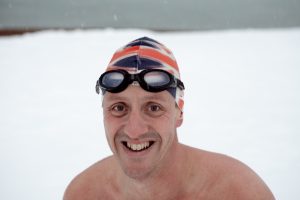 Dr. Mark Harper with a swimming cap and goggles outside in the winter