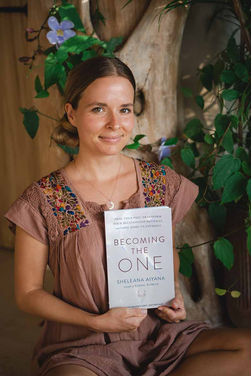 Sheleana Aiyana holding her book "Becoming the One"