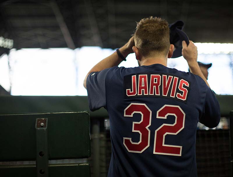 Chase Jarvis stands with his back to camera in a baseball uniform