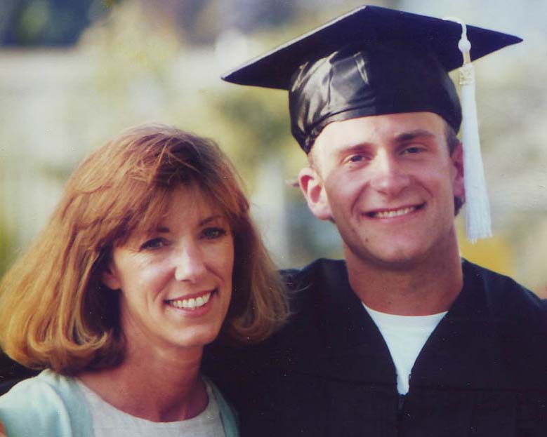 Chase Jarvis stands smiling in a black graduation cap and gown with his arm wrapped around his smiling mother